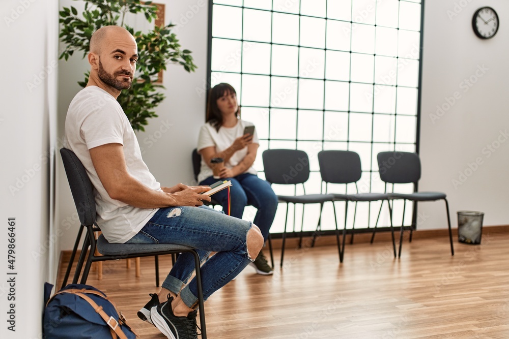 Two hispanic person boring using smartphone at waiting room. Two hispanic person boring using smartphone at waiting room.