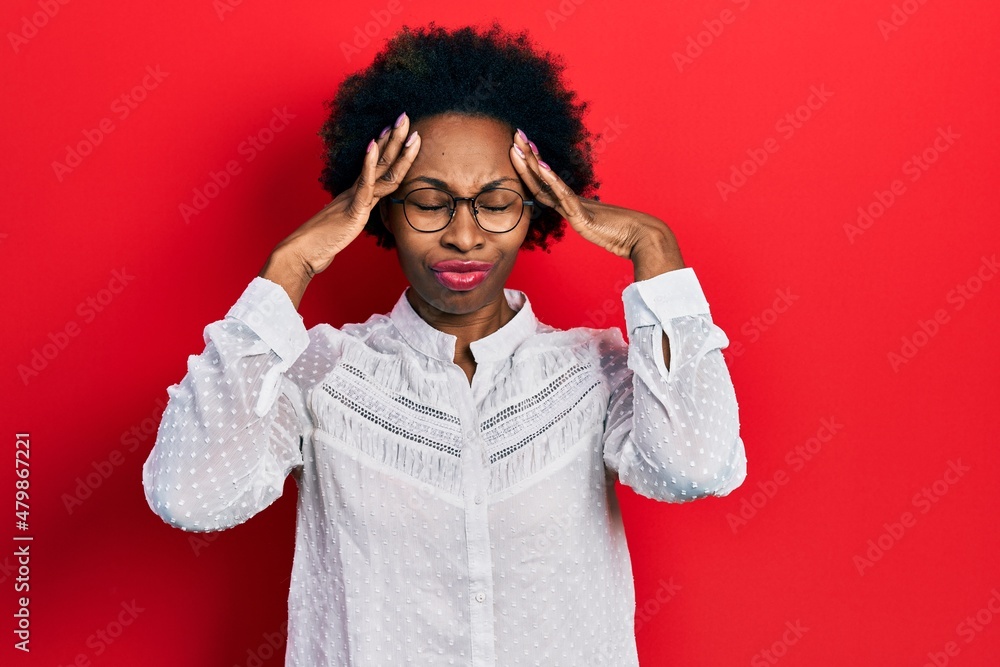 Young african american woman wearing casual clothes and glasses suffering from headache desperate and stressed because pain and migraine. hands on head. Young african american woman wearing casual clothes and glasses suffering from headache desperate and stressed because pain and migraine. hands on head.