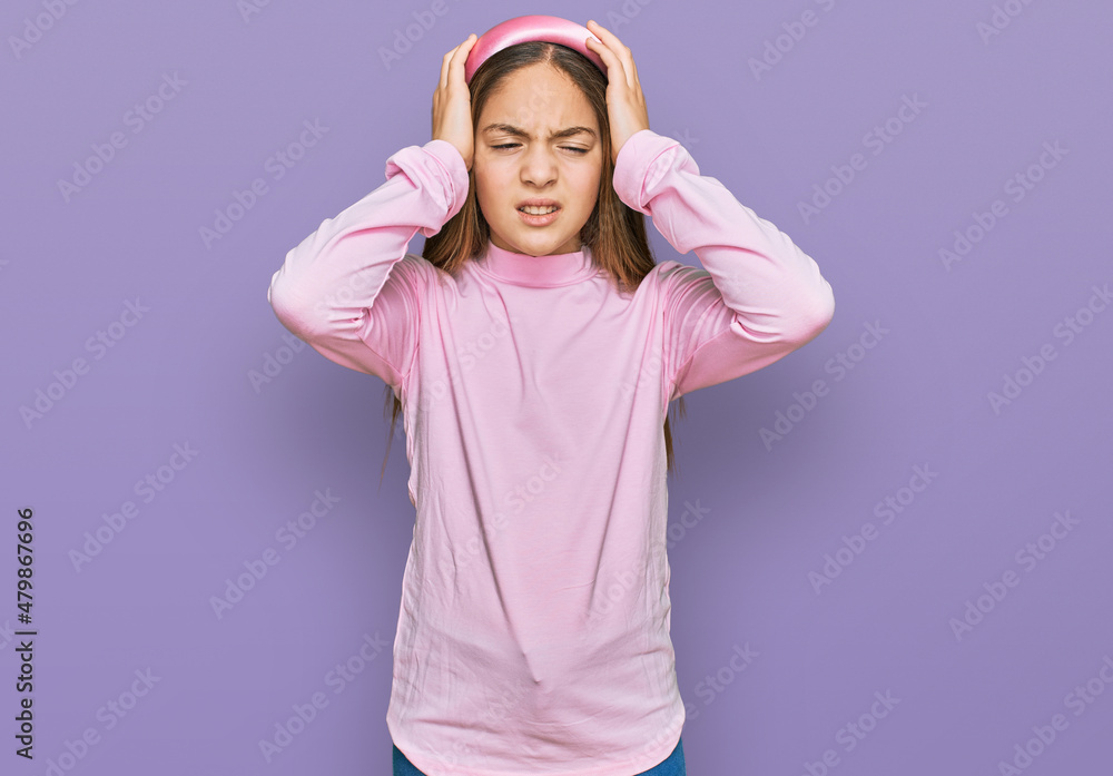 Fototapeta premium Beautiful brunette little girl wearing casual turtleneck sweater suffering from headache desperate and stressed because pain and migraine. hands on head.