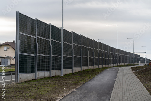 noise barriers along the road with a pedestrian path and a bicycle path