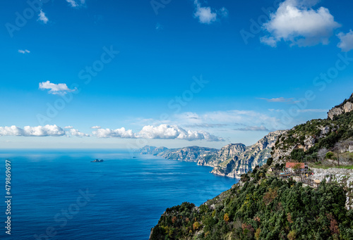 View of the Sorrentine Peninsula and Capri along the Amalfi Coast of Italy, with Tyrhennian Sea under blue skies and clouds