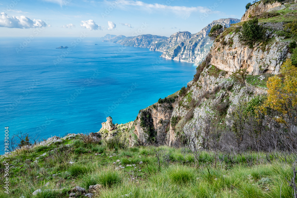 View of the Sorrentine Peninsula and Capri along the Amalfi Coast of Italy, with Tyrhennian Sea under blue skies and clouds