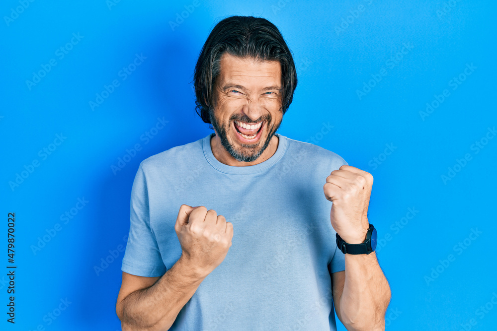Middle age caucasian man wearing casual clothes celebrating surprised and amazed for success with arms raised and eyes closed. winner concept. Middle age caucasian man wearing casual clothes celebrating surprised and amazed for success with arms raised and eyes closed. winner concept.