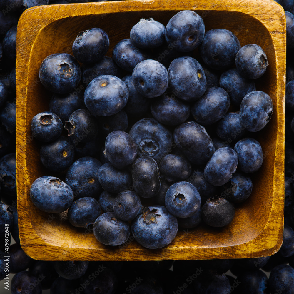 Close-up. Blue fresh blueberries in a yellow bowl. High angle view. Delicious vitamin product, juice, fresh, pie filling, sauces. Advertising. There are no people in the photo. Background Texture Close-up. Blue fresh blueberries in a yellow bowl. High angle view. Delicious vitamin product, juice, fresh, pie filling, sauces. Advertising. There are no people in the photo. Background Texture