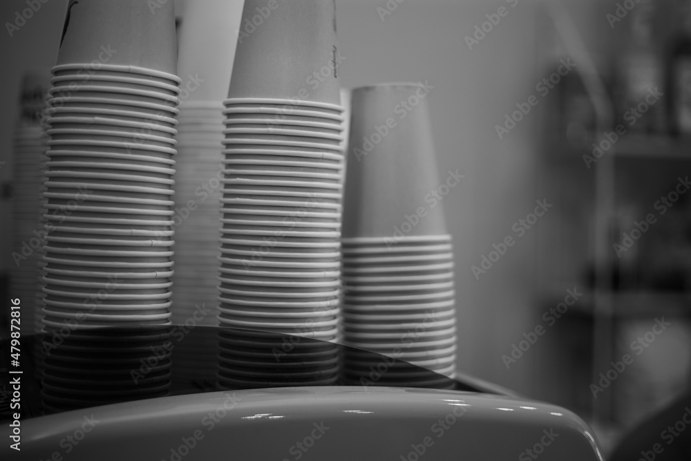 Stacked paper coffee cups stand on coffee machine Stacked paper coffee cups stand on coffee machine