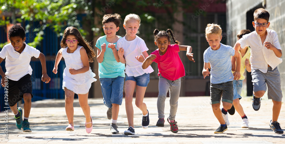 Obraz premium Group of happy kids running in race in the street and laughing outdoors