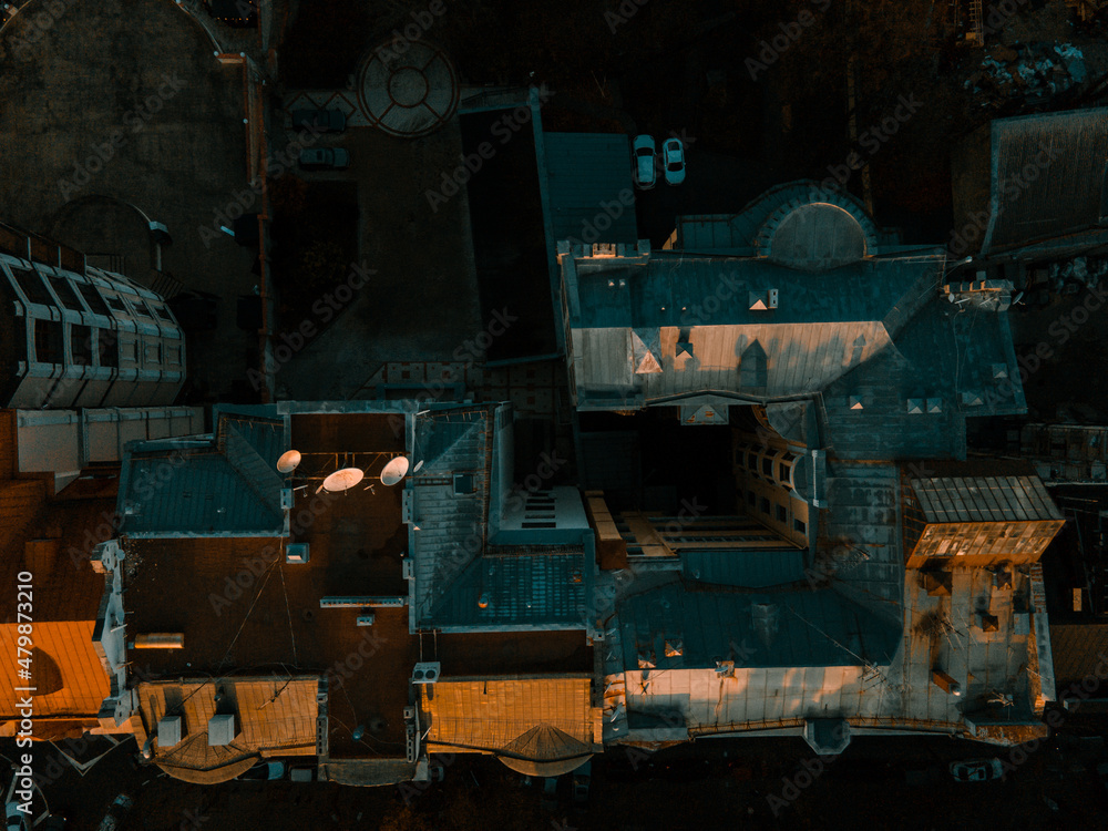 Aerial view from the drone on the roofs of houses and buildings at sunset in town Aerial view from the drone on the roofs of houses and buildings at sunset in town