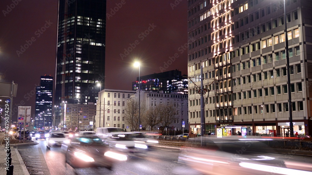 Fototapeta premium Cityscape in early night time with urban traffic. Street in the city in winter. Fast moving cars