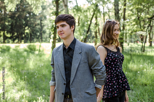 The guy leads the girl by the hand. A couple in love walks in a spring park holding hands. A happy young family spends time together. © Maryna