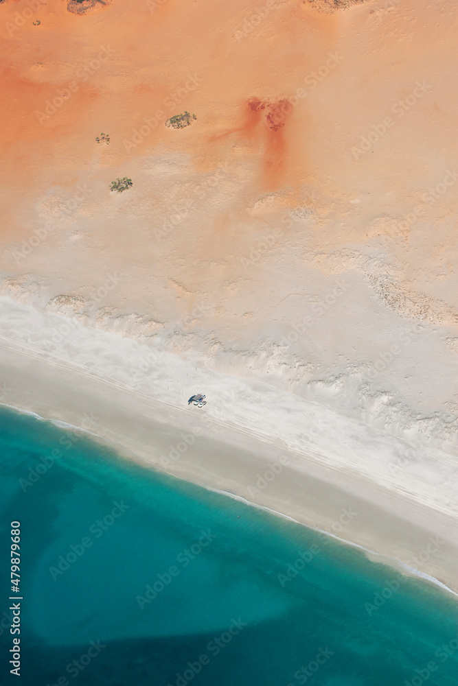 Four wheel drive vehicles sit on an Indian Ocean beach south of Cape Leveque in the Broome region of Western Australia in Australia. This region is also known as the West Kimberley.