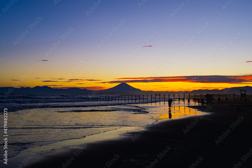 夏の海に沈む夕陽と富士山