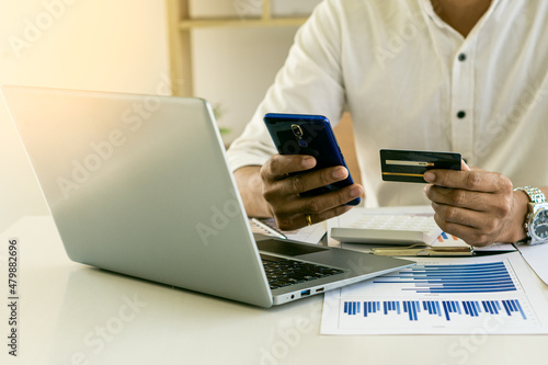 Online shopping concept paying via credit card with laptop computer and smartphone.