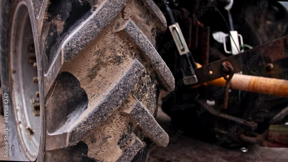 Industrial Tractor Heavy Duty Rear Wheel Tire With Tread Covered In Mud 