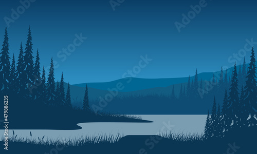 Silhouette of dramatic mountains in the morning with pine trees from the lakeside