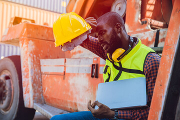 Tired stress worker sweat from hot weather in summer working in port goods cargo shipping logistic ground, Black African race people.