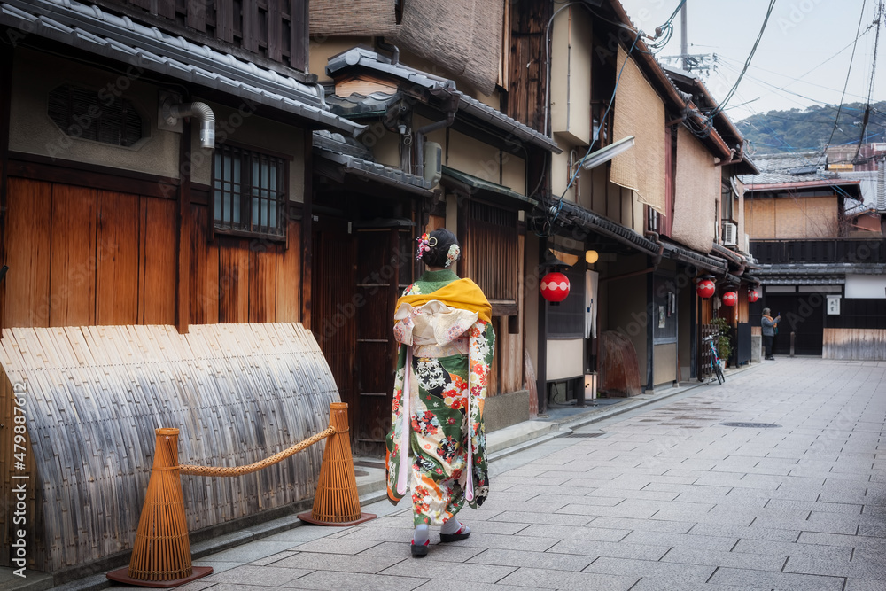Young woman dressed in kimono, walking down the street in Gion, Kyoto, Japan