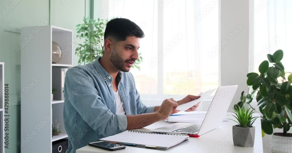 Young businessman using laptop for video conference at office Young businessman using laptop for video conference at office