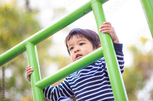 Jpyful asian boy climb on row in colorful playground © themorningglory