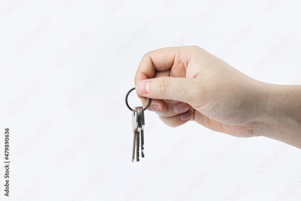 Hand holding key on white background. concept of home safety. Buying and selling a house. Hand holding key on white background. concept of home safety. Buying and selling a house.
