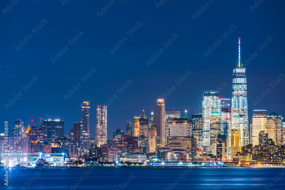 Obraz premium new york city skyline at night with reflection in hudson river.