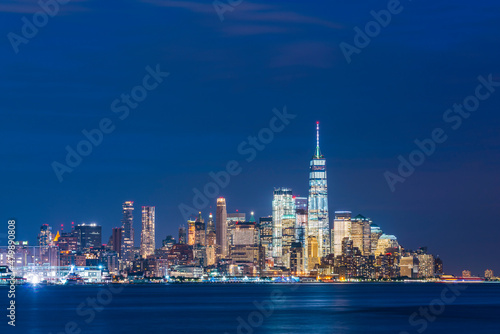  new york city skyline  at night with reflection in hudson river.