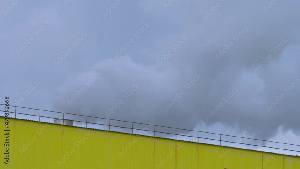 Strong wind blow white smoke from chimney on roof. Supply shortage and volatile market for natural gas concept. Central heating system provides warmth of spaces building Strong wind blow white smoke from chimney on roof. Supply shortage and volatile market for natural gas concept. Central heating system provides warmth of spaces building