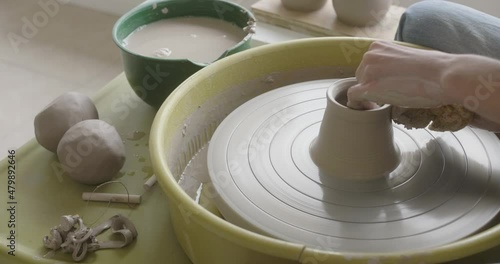 A potter making a mug at the pottery wheel. photo