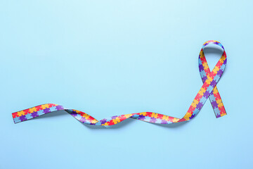 Awareness ribbon on blue background. Concept of autistic disorder