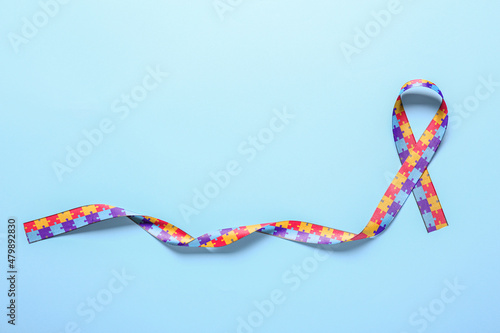 Awareness ribbon on blue background. Concept of autistic disorder photo