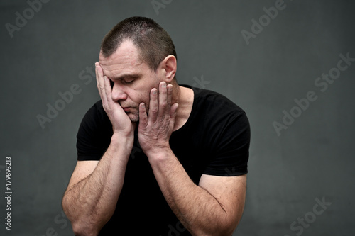 portrait of a man worried upset with his hands covering his face