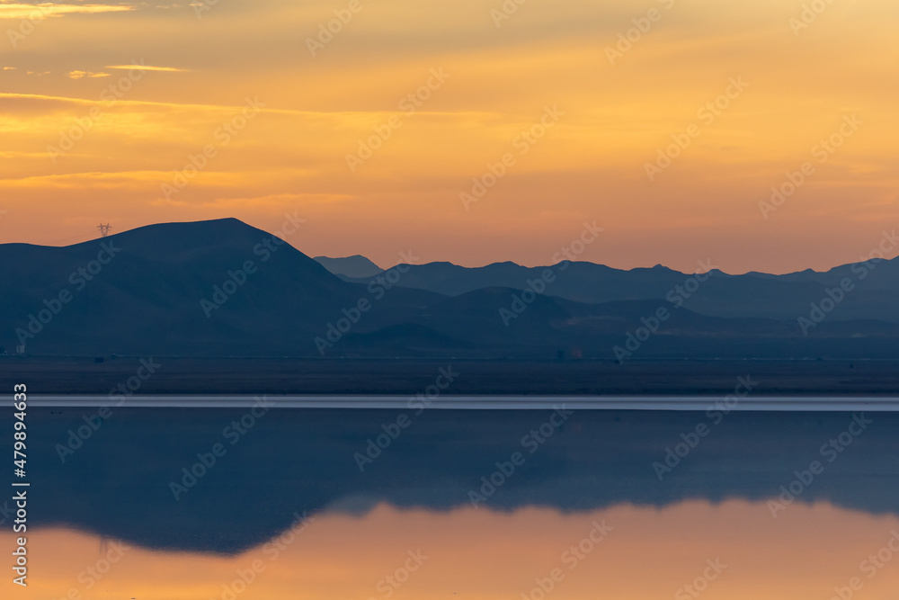 Reflection of the sunset and the mountain in the salt lake