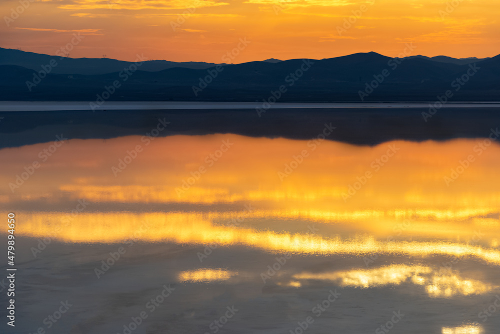 Reflection of the sunset and the mountain in the salt lake