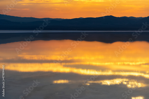 Reflection of the sunset and the mountain in the salt lake