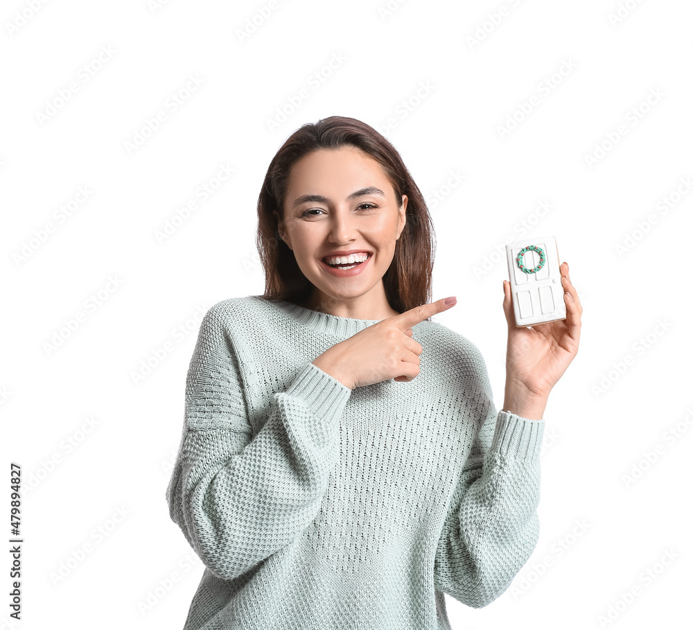 Smiling young woman pointing at gingerbread cookie on white background Smiling young woman pointing at gingerbread cookie on white background