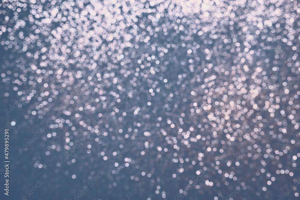 Festive Blue background of silver glitter lights. Winter blurred abstraction Festive Blue background of silver glitter lights. Winter blurred abstraction