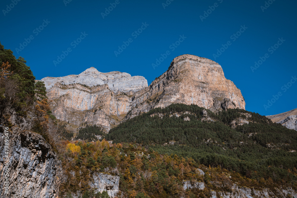Mountains in a blue sky with clouds day, in Torla, Huesca, Aragon, Spain. Alpine canyon landscape in Ordesa and Monte Perdido national park, in the Spanish Pyrenees