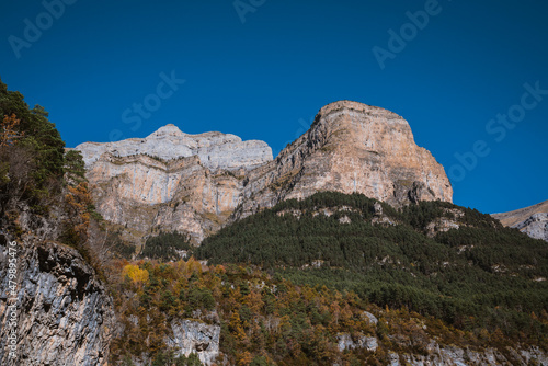 Mountains in a blue sky with clouds day  in Torla  Huesca  Aragon  Spain. Alpine canyon landscape in Ordesa and Monte Perdido national park  in the Spanish Pyrenees