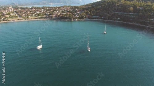 Aerial view of three sail boat in a clear water sea bay surrounded by wild vegetation in east Sardinia coastline photo