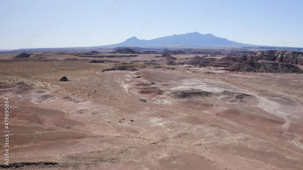 An aerial drone shot of an RV off-road driving through the Utah desert on an American roadtrip An aerial drone shot of an RV off-road driving through the Utah desert on an American roadtrip