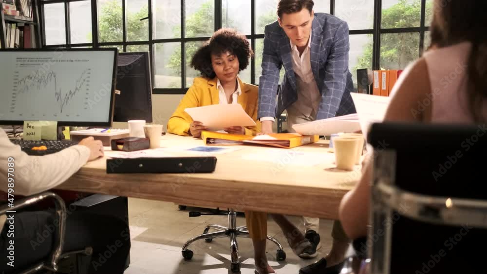 The company staff, group of multiracial workers work with computers and team brainstorming at the open workspace, talking and discussing with a Caucasian male boss at the marketing business office. The company staff, group of multiracial workers work with computers and team brainstorming at the open workspace, talking and discussing with a Caucasian male boss at the marketing business office.