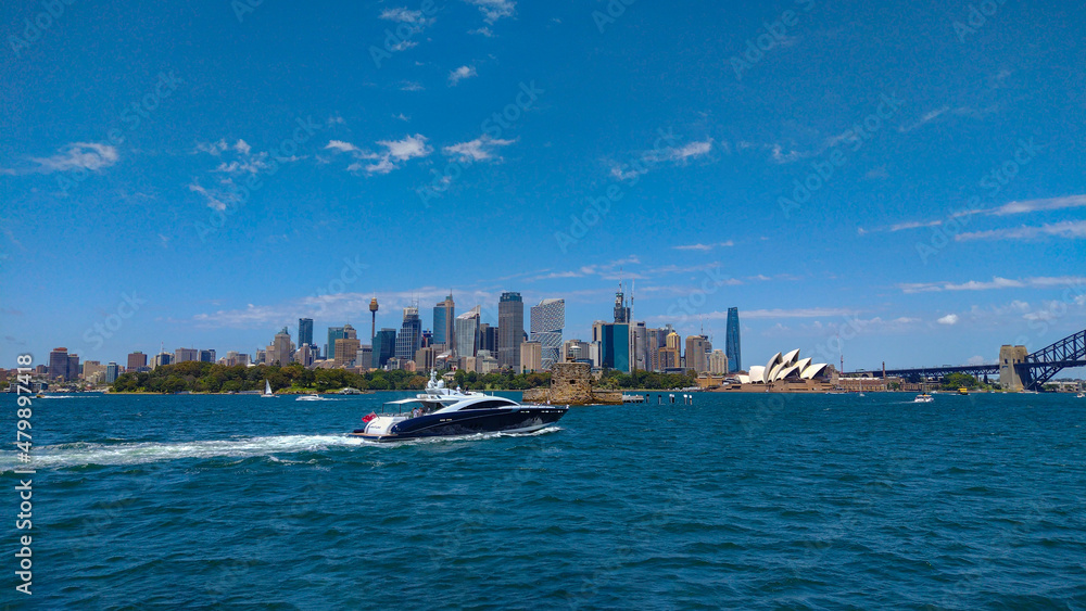 Naklejka premium A large boat passes by on the Sydney Harbour with Sydney City in the background on a sunny day 