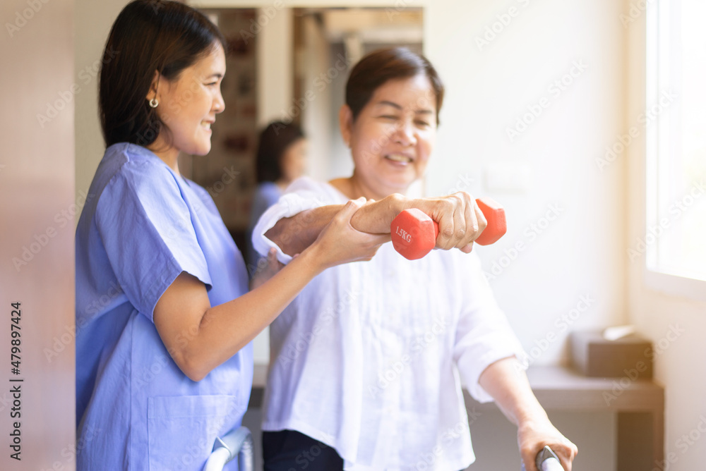 Physiotherapist woman training with senior patient using dumbbells in clinic,Physical therapy concept Physiotherapist woman training with senior patient using dumbbells in clinic,Physical therapy concept