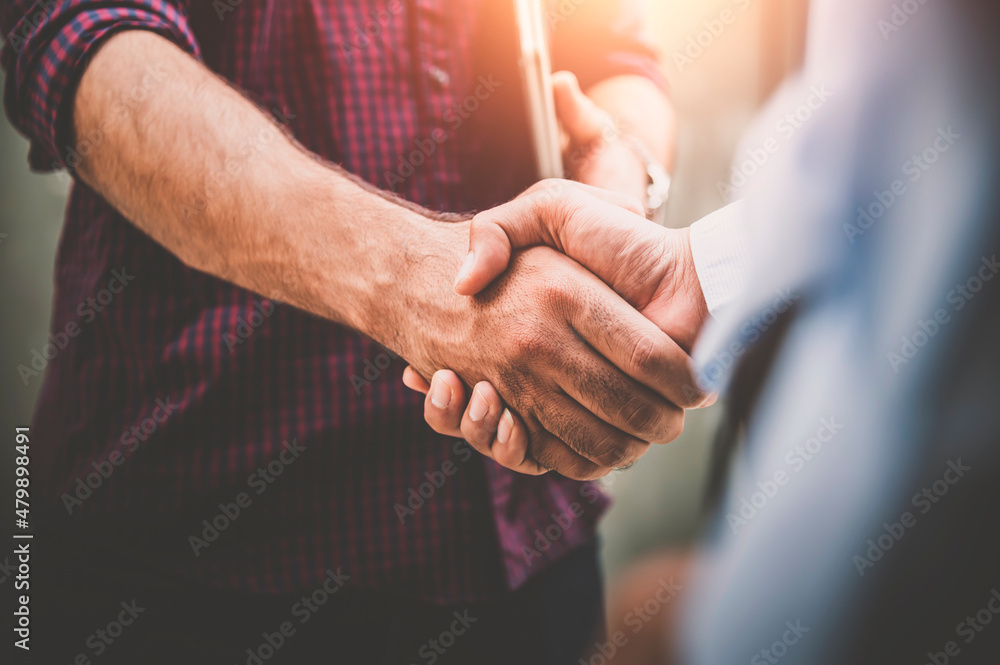 Two businessman shaking hands with business deals and congratulations on success.