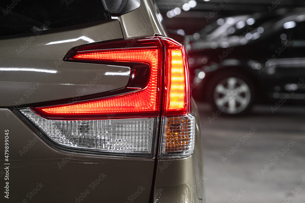 glowing tailight of a modern silver suv close-up. Exterior detail .