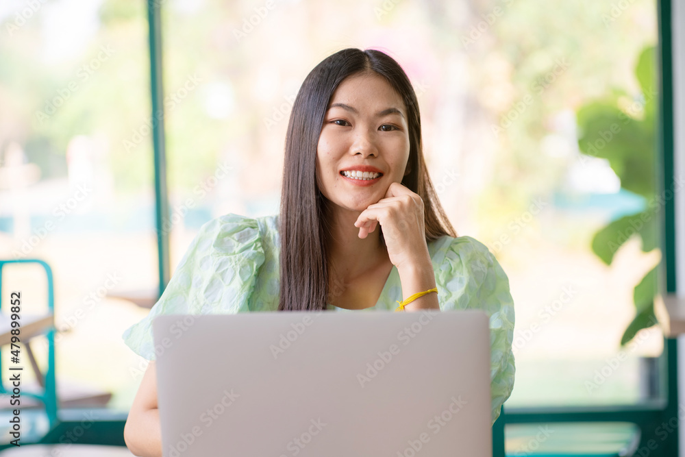 Business casual women working with laptop sitting in coffee shop