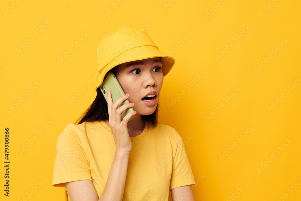 Portrait Asian beautiful young woman in a yellow hat and T-shirt talking on the phone Lifestyle unaltered Portrait Asian beautiful young woman in a yellow hat and T-shirt talking on the phone Lifestyle unaltered