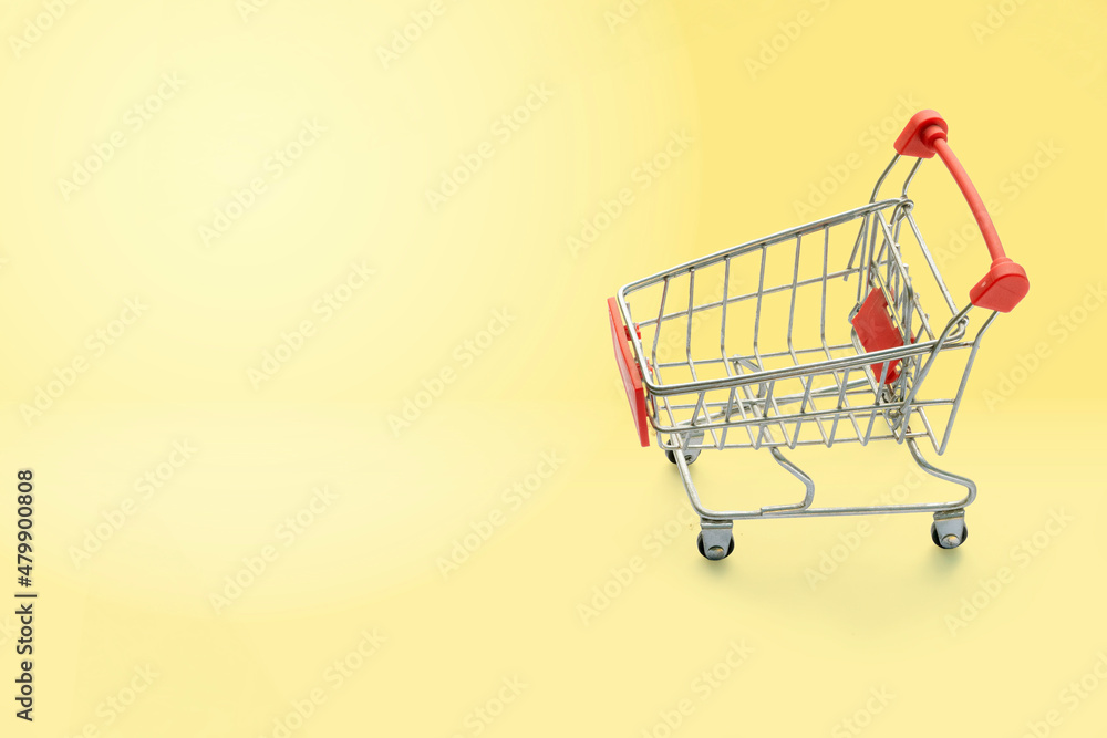 shopping trolley on yellow background with some copy space. shopping trolley on yellow background with some copy space.