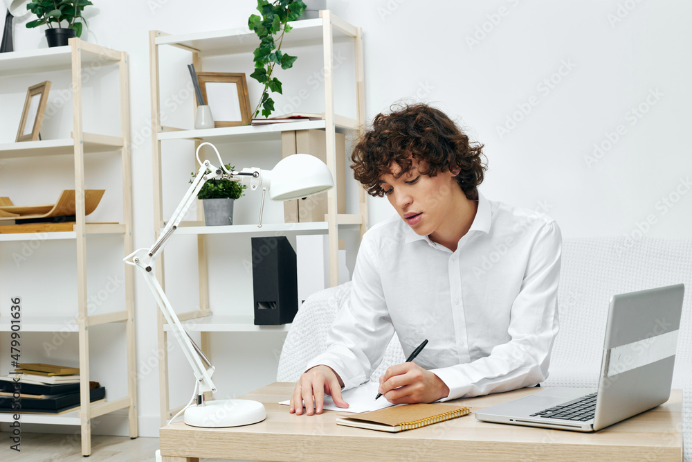 curly guy on a white sofa in front of a laptop learning communication curly guy on a white sofa in front of a laptop learning communication
