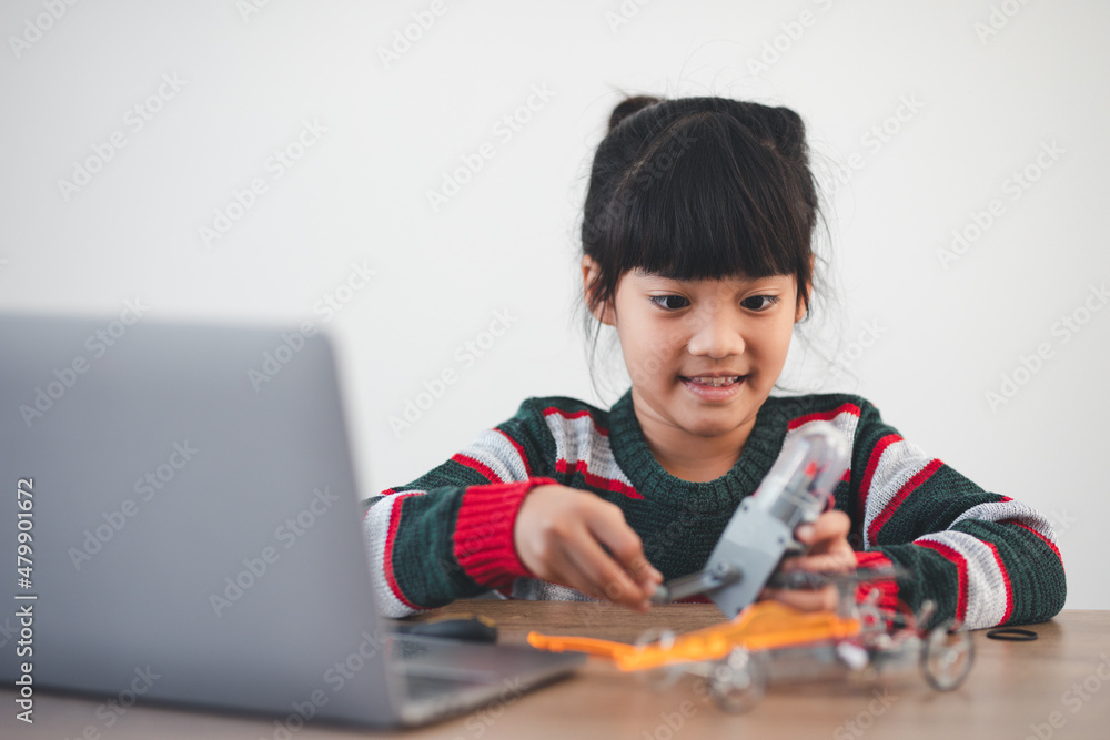 Inventive kid constructing robot cars at home Inventive kid constructing robot cars at home