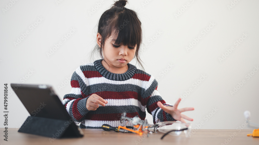 Inventive kid constructing robot cars at home Inventive kid constructing robot cars at home
